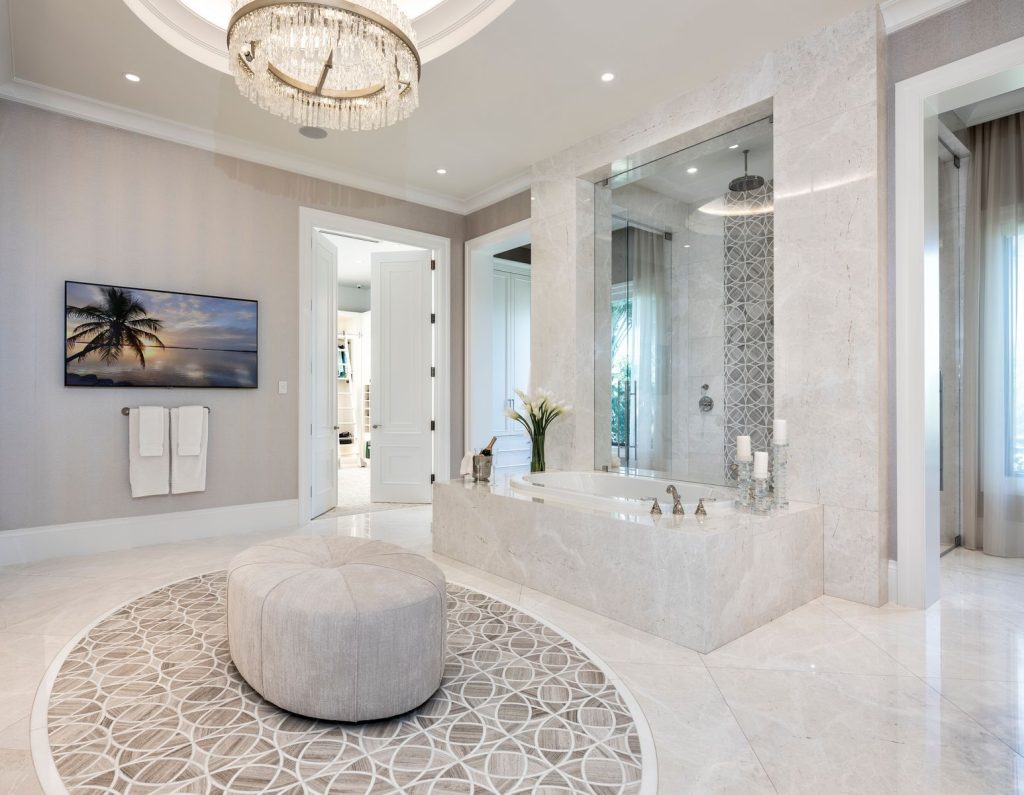 A large bathroom with a round rug and a television.